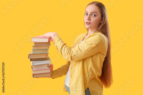 Young woman with stack of b...