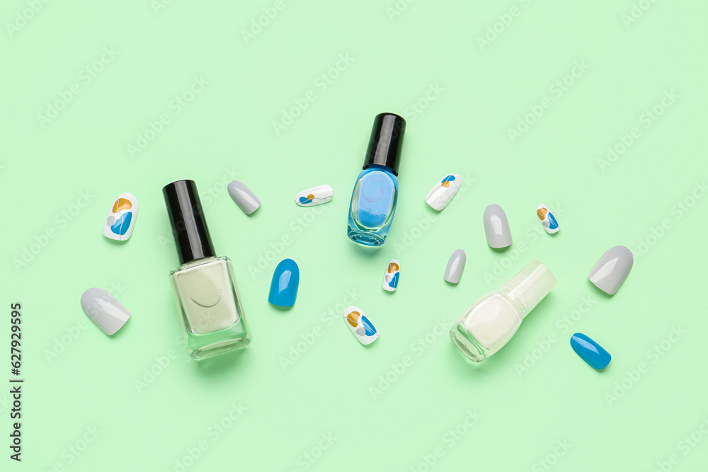 Press-on nails with polishes on green background Press-on nails with polishes on green background
