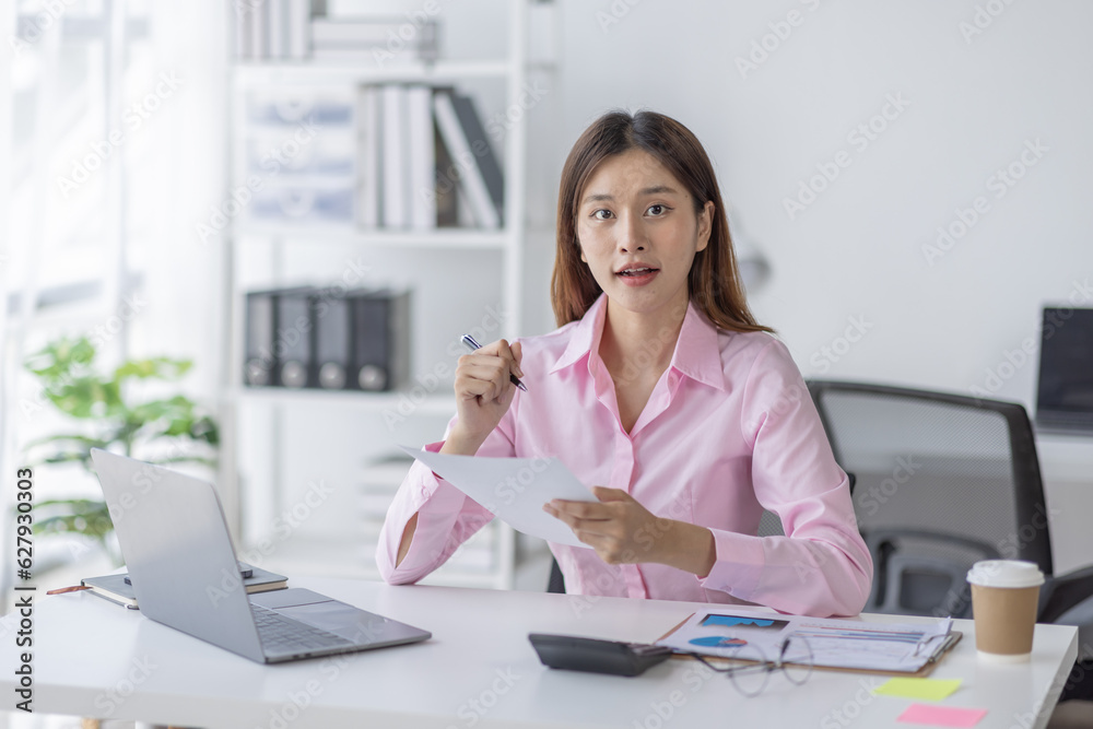Asian Businesswoman Using laptop computer and working at office with calculator document on desk, doing planning analyzing the financial report, business plan investment, finance analysis concept.
Asian Businesswoman Using laptop computer and working at office with calculator document on desk, doing planning analyzing the financial report, business plan investment, finance analysis concept.
