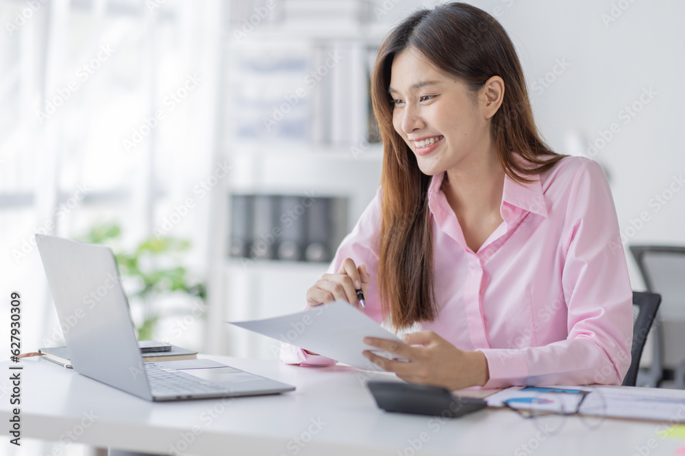 Asian Businesswoman Using laptop computer and working at office with calculator document on desk, doing planning analyzing the financial report, business plan investment, finance analysis concept.
Asian Businesswoman Using laptop computer and working at office with calculator document on desk, doing planning analyzing the financial report, business plan investment, finance analysis concept.