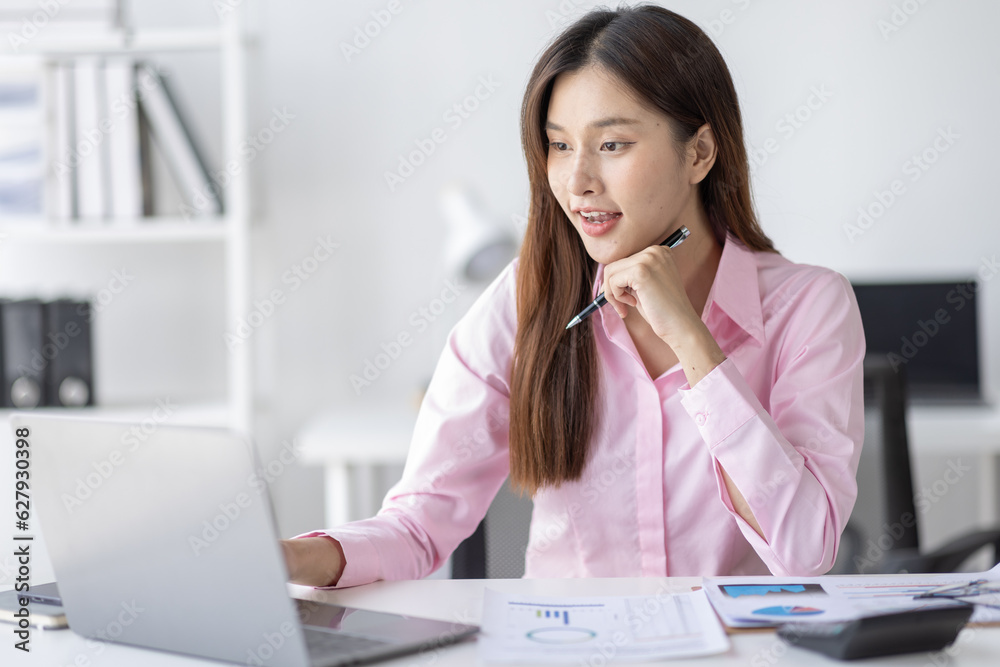 Asian Businesswoman Using laptop computer and working at office with calculator document on desk, doing planning analyzing the financial report, business plan investment, finance analysis concept.
Asian Businesswoman Using laptop computer and working at office with calculator document on desk, doing planning analyzing the financial report, business plan investment, finance analysis concept.