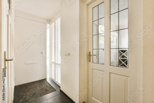 a white door in a room with black tile flooring and wooden shutters on the wall behind it is a large mirror