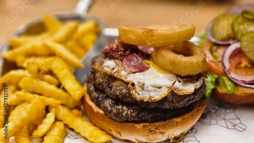 hamburger burger with ban french fries on table bacon egg onion