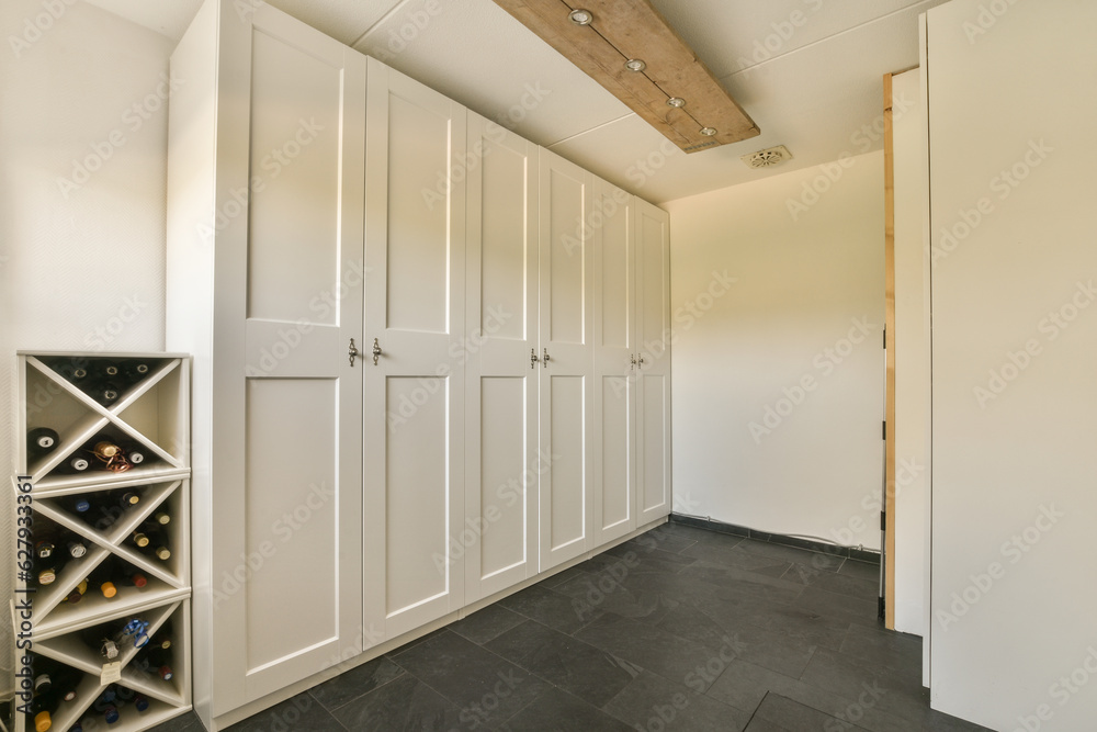 a wine rack in the corner of a room with white cupboards and shelves on the wall is made out of wood a wine rack in the corner of a room with white cupboards and shelves on the wall is made out of wood