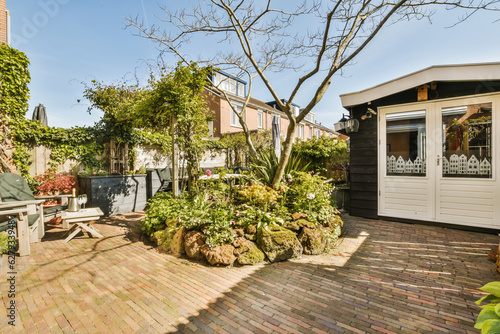 a backyard area with brick pavers and potted trees in the fore - image is taken from outside © Casa imágenes
