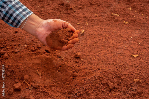 Soil held in his hands, the farmer nurtures the potential for a bountiful harvest.