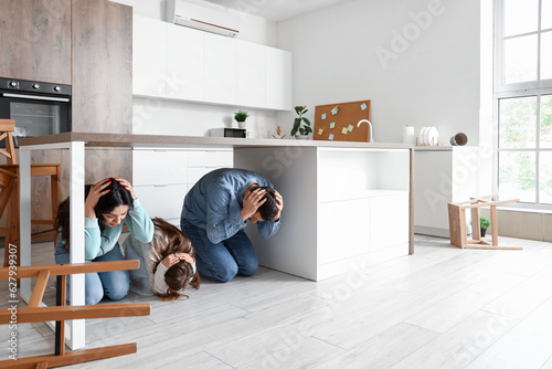 Scared family hiding under ...