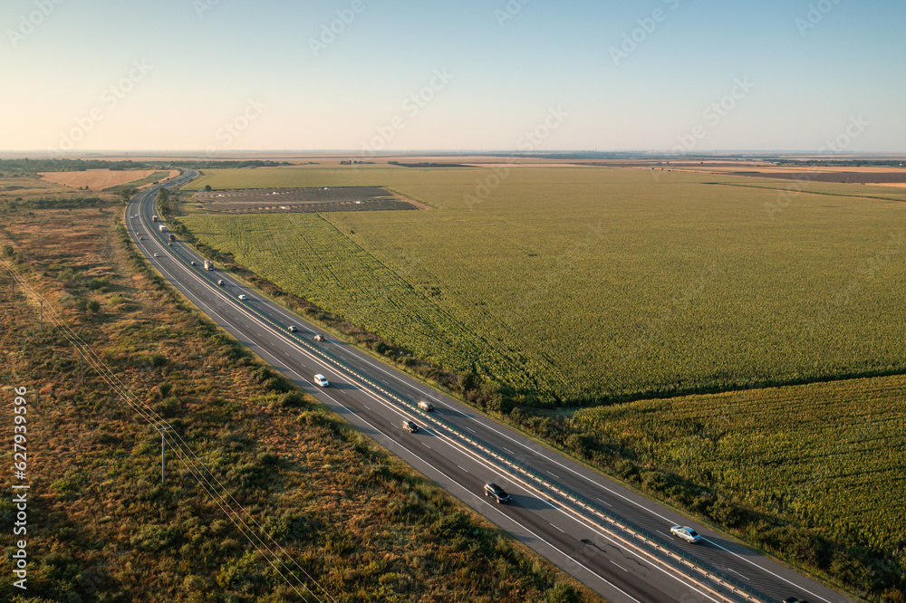 A2 highway in Romania. Aerial photo with motorway road from Bucharest to Constanta during a beautiful summer sunrise. High speed infrastructure industry.
