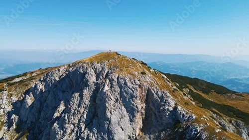 Stunning 4K drone footage of Saddle bellow Kordezeva Glava - Peca mountain in Karavanke mountain range. Beautiful Slovenian scenery of peaks of Kamnik-Savinja Alps in the background. Summer time. photo