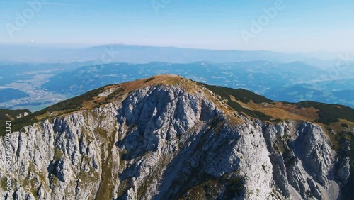 Stunning 4K drone footage of Saddle bellow Kordezeva Glava - Peca mountain in Karavanke mountain range. Beautiful Slovenian scenery of peaks of Kamnik-Savinja Alps in the background. Summer time. photo