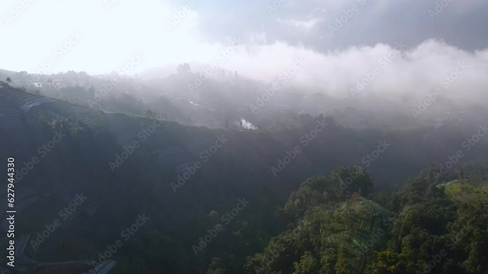 Aerial view of majestic mountain landscape with flying Clouds and fog in countryside of Indonesia Aerial view of majestic mountain landscape with flying Clouds and fog in countryside of Indonesia