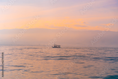 Tourists looking for dolphins at Lovina in Bali. Morning boat trips.