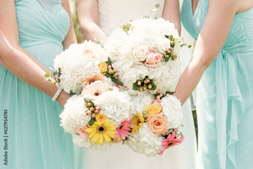 Floral bridal bouquets held by bridal party in teal dresses Floral bridal bouquets held by bridal party in teal dresses