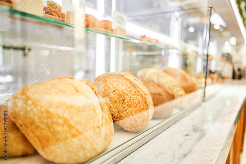 Different kinds of bread on the counter in the bakery shop. Fresh bread counter. Modern bakery with different kinds of bread, cakes and buns 