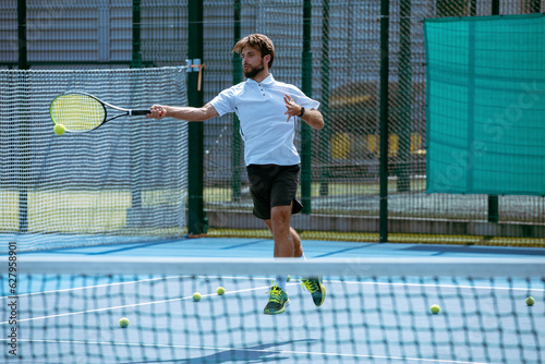 Obraz na plátně Tennis player training on a professional tennis court.