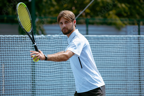 Tennis player training on a professional tennis court. © VIAR PRO studio