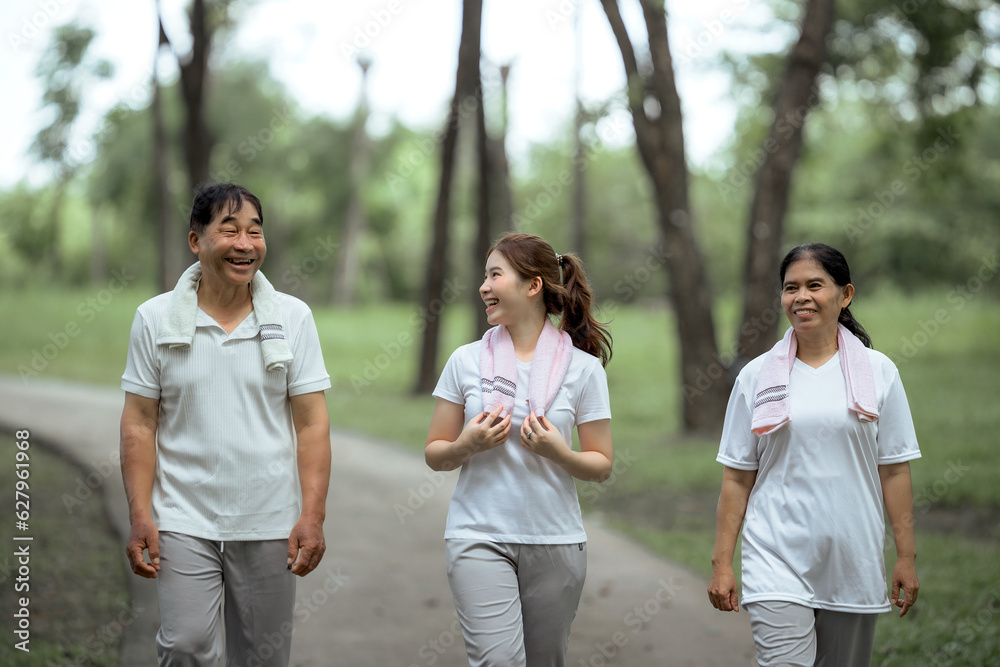 Beautiful Asian woman taking her father and mother to exercise in the park happily, with a smile. Young woman invites parents to exercise, warm family, good health. concept health care life insurance. Beautiful Asian woman taking her father and mother to exercise in the park happily, with a smile. Young woman invites parents to exercise, warm family, good health. concept health care life insurance.