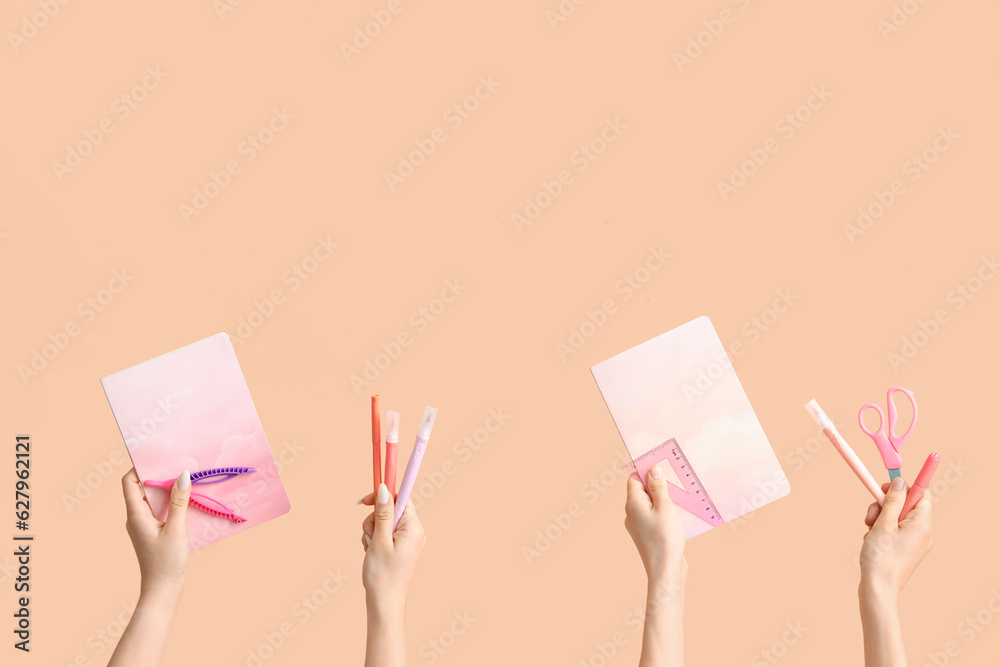 Female hands with school supplies on beige background Female hands with school supplies on beige background