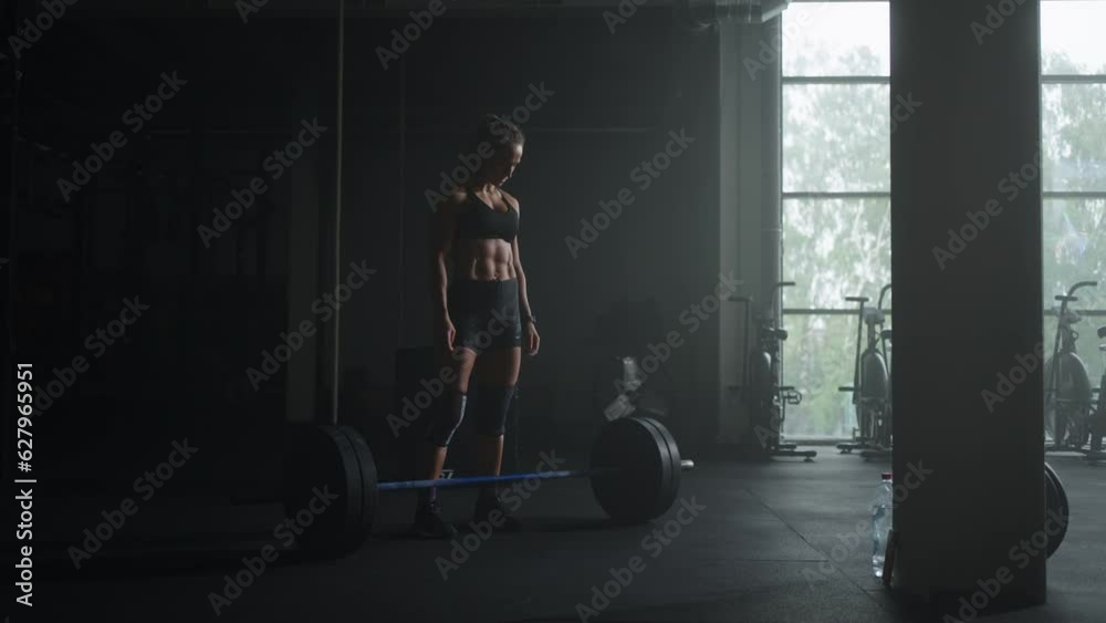 Powerlifter Woman Training Alone In Dark Fitness Club, Approaching To Barbell, Female Silhouette Powerlifter Woman Training Alone In Dark Fitness Club, Approaching To Barbell, Female Silhouette