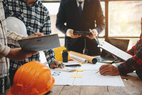 Engineer teams meeting working together wear worker helmets hardhat on construction site in modern city.