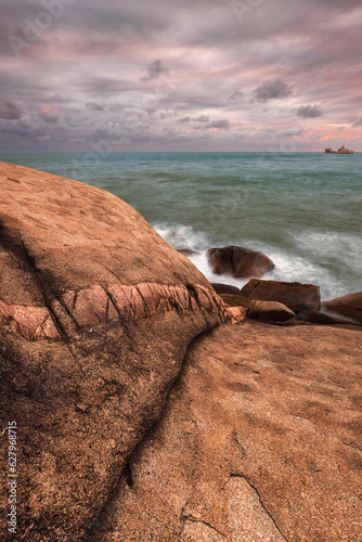 Rocks on beach near green ocean at magnetic island