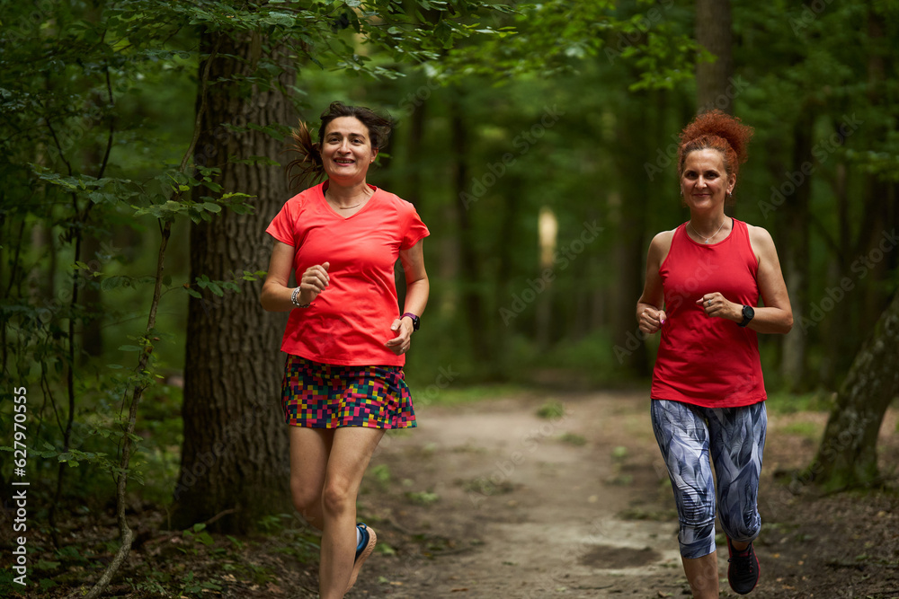Happy ladies jogging in the forest Happy ladies jogging in the forest