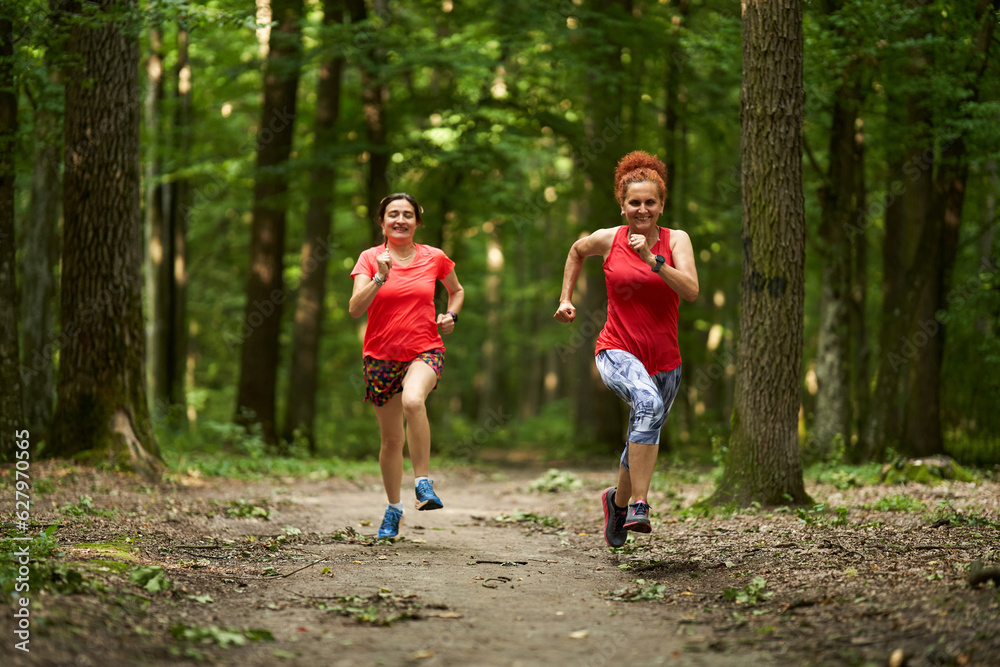 Fototapeta premium Happy ladies jogging in the forest