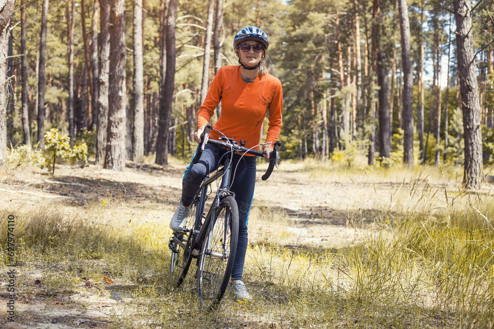 woman cyclist rides in the forest on a mountain bike.