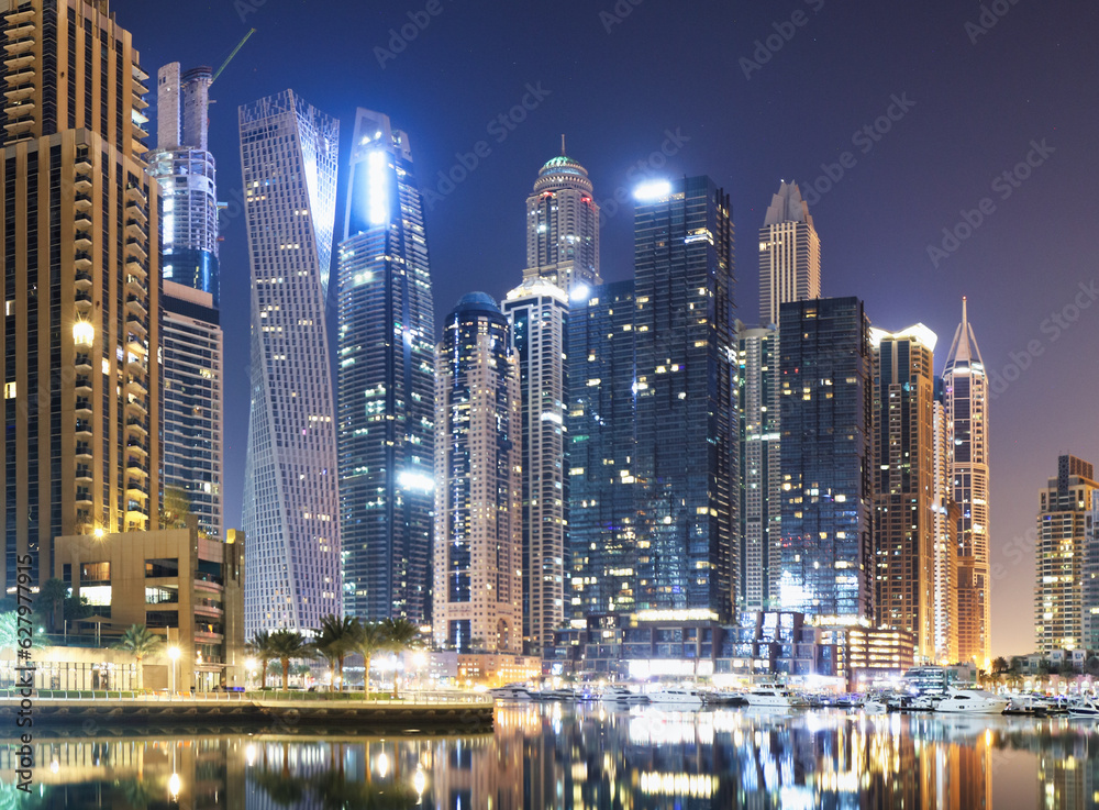 Promenade and canal in Dubai Marina at night with luxury skyscrapers around,United Arab Emirates