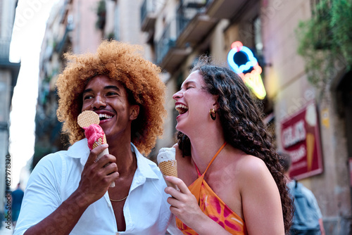 young multiehtnic couple of tourists in Barcelona eating ice cream