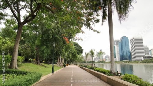 Wallpaper Mural Benchakitti Park in Bangkok. Nearby, the skyscrapers of the business district are visible. A place of relaxation for residents, with a path around green areas. Skyscrapers, Urban park, Cityscape. Torontodigital.ca