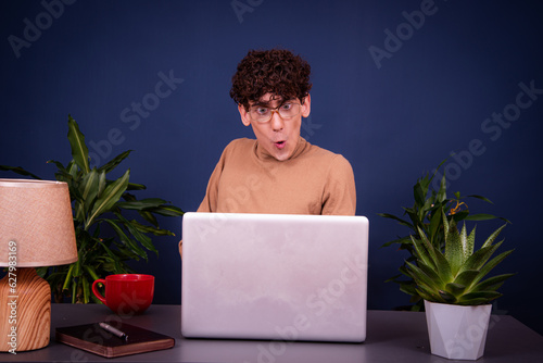 Obraz na płótnie Funny silly guy communicates online, studies and solves issues at work