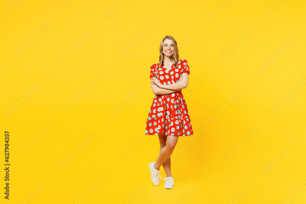 Full body young smiling cheerful happy caucasian woman she wear red dress casual clothes hold hands crossed folded look camera isolated on plain yellow background studio portrait. Lifestyle concept. Full body young smiling cheerful happy caucasian woman she wear red dress casual clothes hold hands crossed folded look camera isolated on plain yellow background studio portrait. Lifestyle concept.