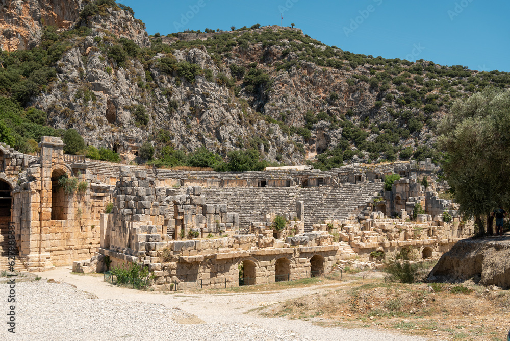 The ruins of the amphitheater and ancient rock tombs in the ancient city of Myra in Demre, Turkey