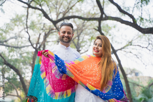 Indian couple in traditional wear and giving happy expression.