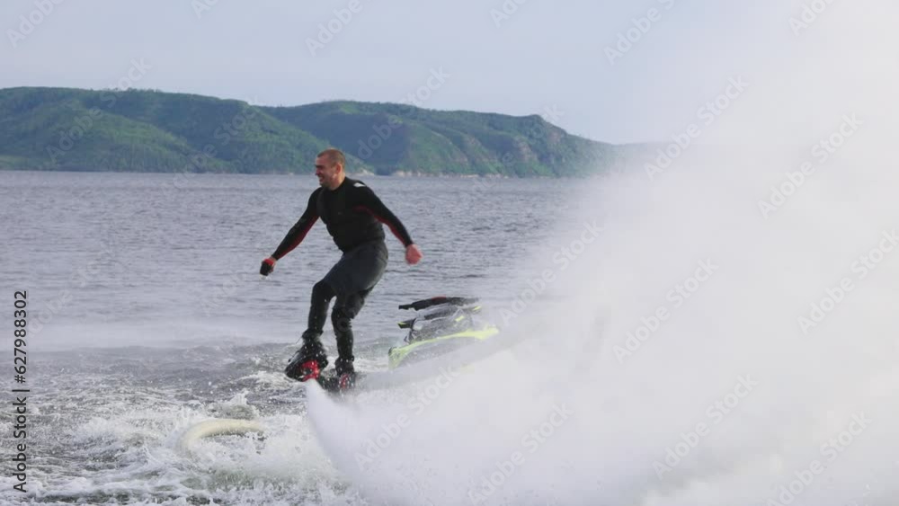 Flyboarding is a new extreme sport where a joyful male flyboarder flies over the water and performs tricks, creating a spectacular display of activity on the water Flyboarding is a new extreme sport where a joyful male flyboarder flies over the water and performs tricks, creating a spectacular display of activity on the water