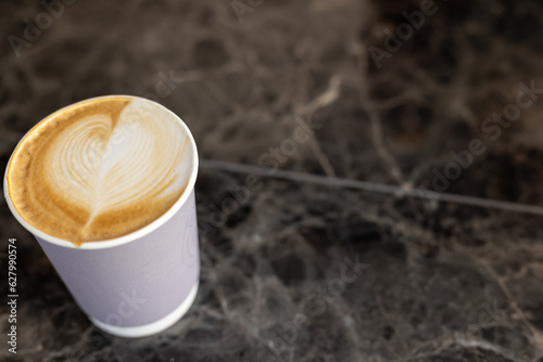 Close up of fresh cup of coffee on black countertop, copy space