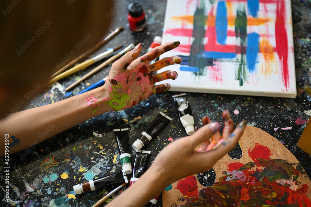 Obraz premium Young man artist concentrating on his painting in bright art studio. Art, education and creative hobby concept