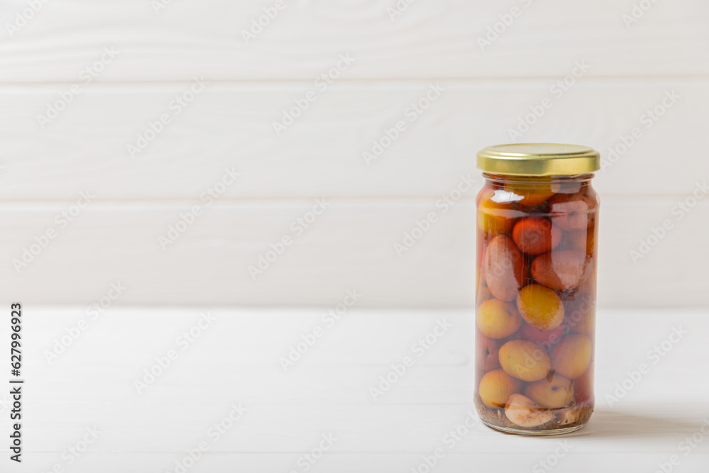 Delicious red olives. Pickled olives in glass jar. On a wooden background.Tasty olives. Close-up. Vegan.Place for text. copy space. Delicious red olives. Pickled olives in glass jar. On a wooden background.Tasty olives. Close-up. Vegan.Place for text. copy space.