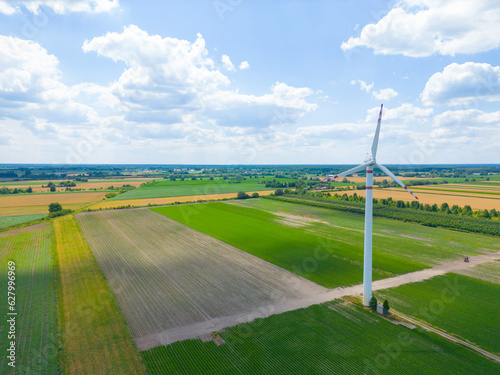 Aerial drone view of wind power turbines  part of a wind farm. Wind turbines on green field in countryside. Wind power plant.