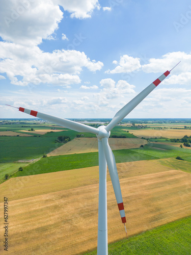 Aerial view of powerful Wind turbine farm for energy production on beautiful cloudy sky at highland. Wind power turbines generating clean renewable energy for sustainable development.