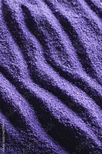 Close up of pattern of purple sand and copy space background