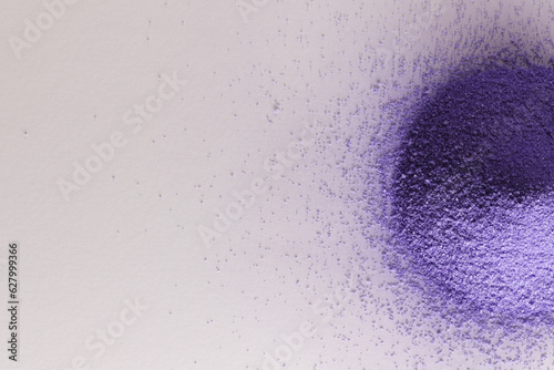 Close up of heap of purple sand and copy space on white background
