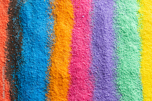 Close up of stripes of rainbow coloured sand and copy space background photo