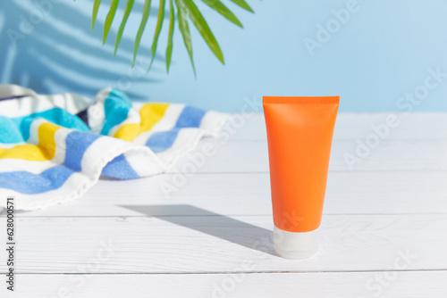 Sunscreen lotion on blue background. Care products summer beach accessories