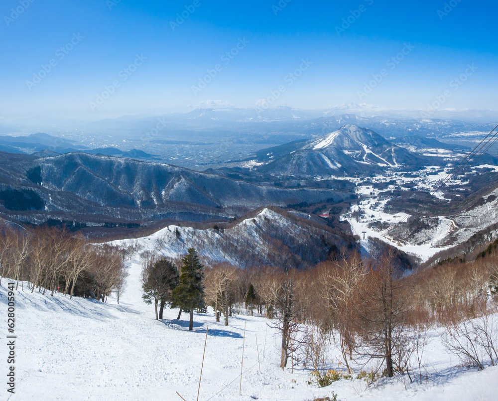 Fototapeta premium Steep ski slope with the view of snowy peaks (Ryuo, Nagano, Japan)