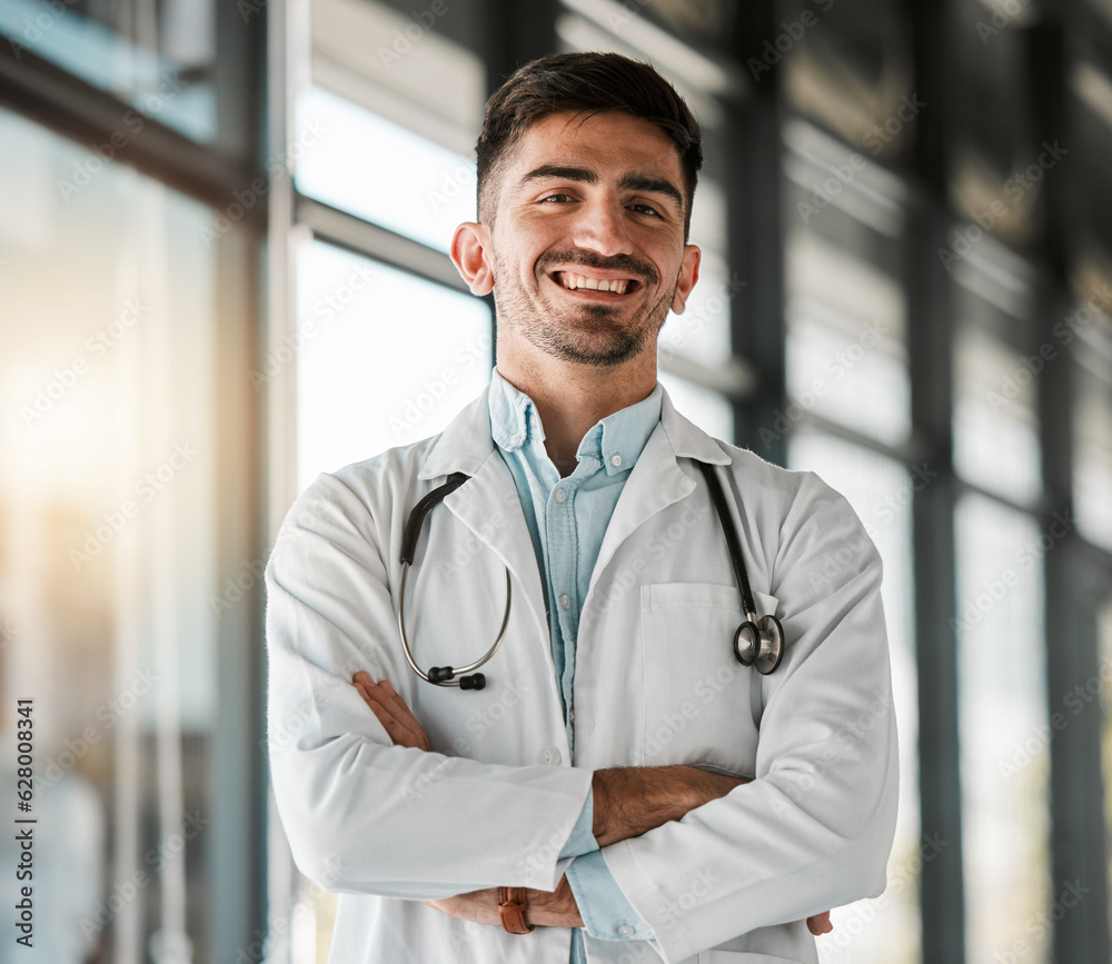 Crossed arms, confidence and portrait of a male doctor with a stethoscope in a medical hospital. Happy, smile and headshot of a professional young man healthcare worker or surgeon in medicare clinic. Crossed arms, confidence and portrait of a male doctor with a stethoscope in a medical hospital. Happy, smile and headshot of a professional young man healthcare worker or surgeon in medicare clinic.