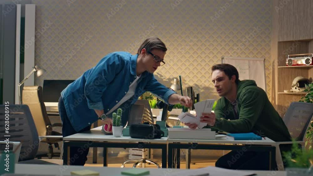 Serious partners advising together at workplace. Freelance guys working remotely Serious partners advising together at workplace. Freelance guys working remotely