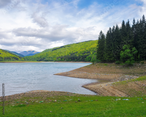 vilshany water reservoir in carpathian mountains. polluted shore of the lake. ecology disaster and climate change concept. water drought photo