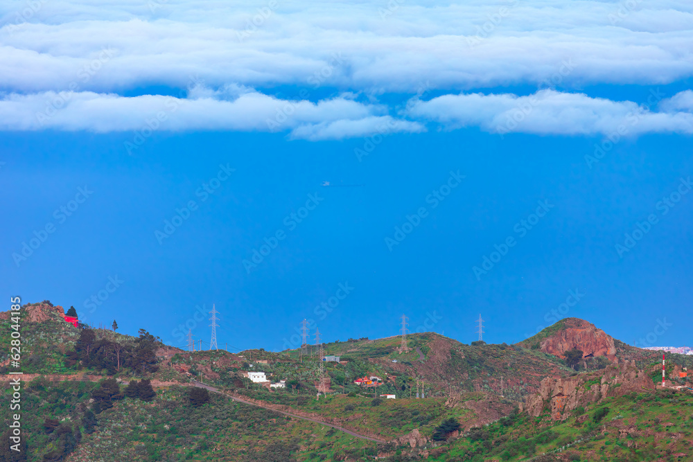 Naklejka premium Mountain landscape with white clouds and blue sky